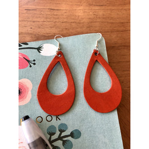 Orange Teardrop Loop Leather Earrings, pictured with notebook and pen