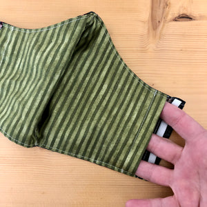 Close up of one side opening of filter pocket on rainbow face mask. There are openings for the filter pocket on both sides of the mask.
